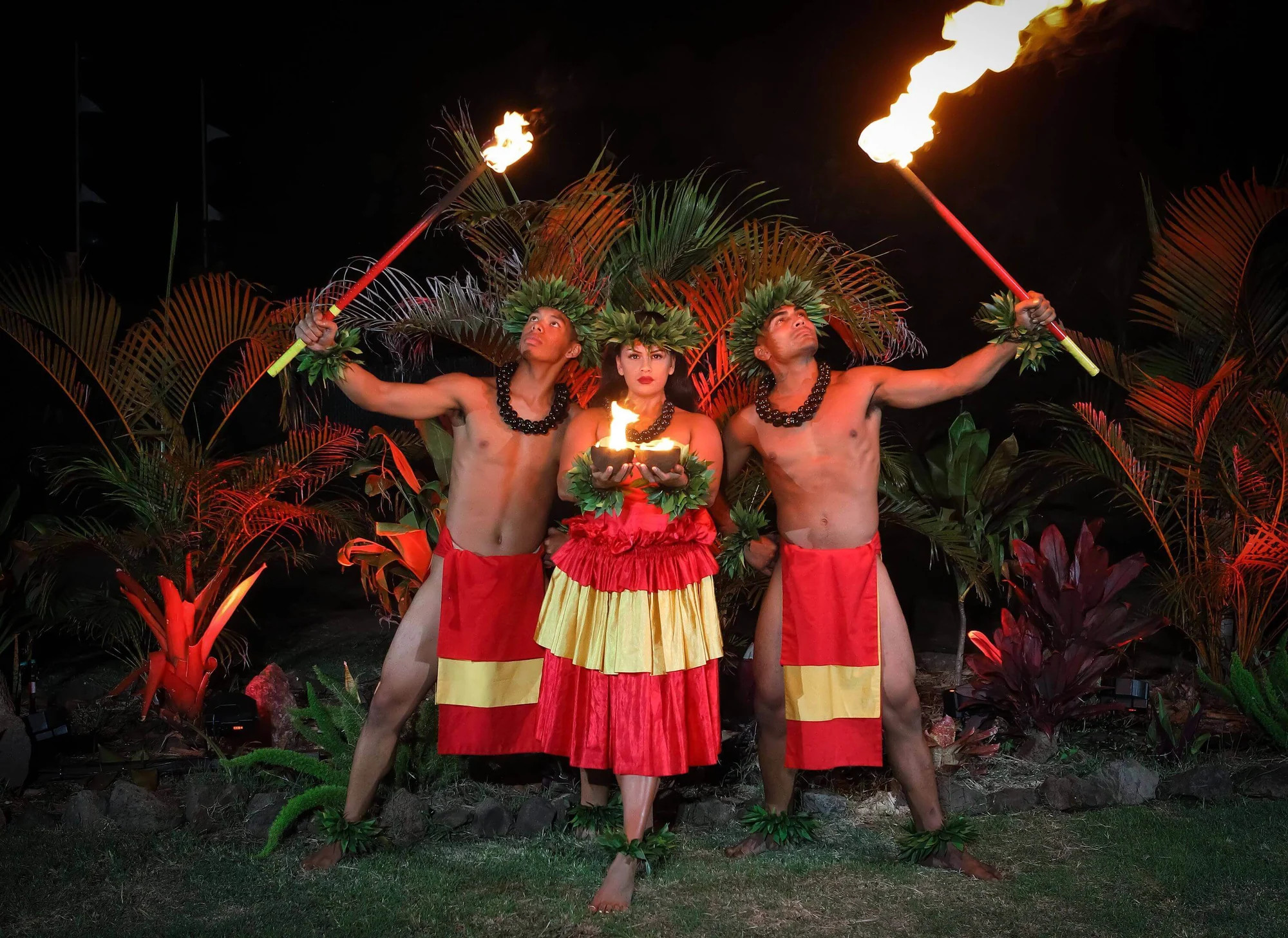 Aloha Kai Luau performers holding torches during the evening show